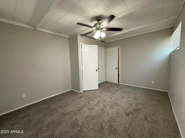 an empty room with wooden floor and window
