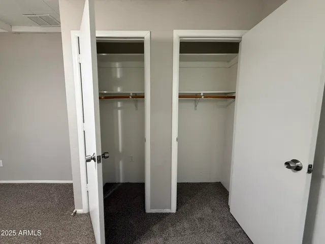 an empty room with wooden floor fireplace and windows