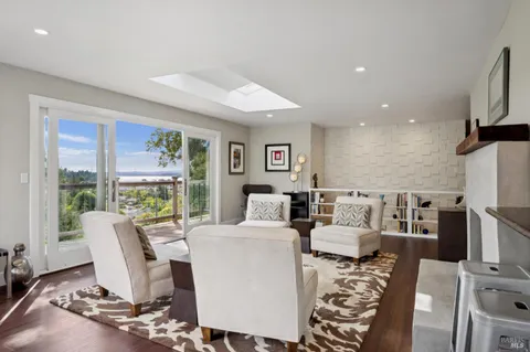 a living room with furniture a large window and a flat screen tv