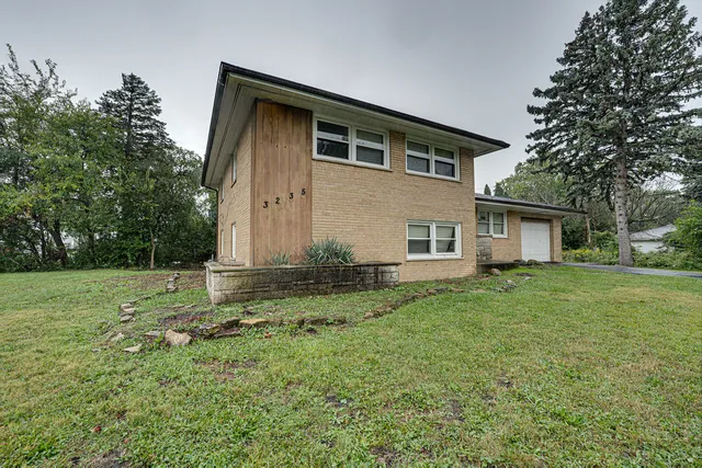 a view of a yard in front of a house with large trees