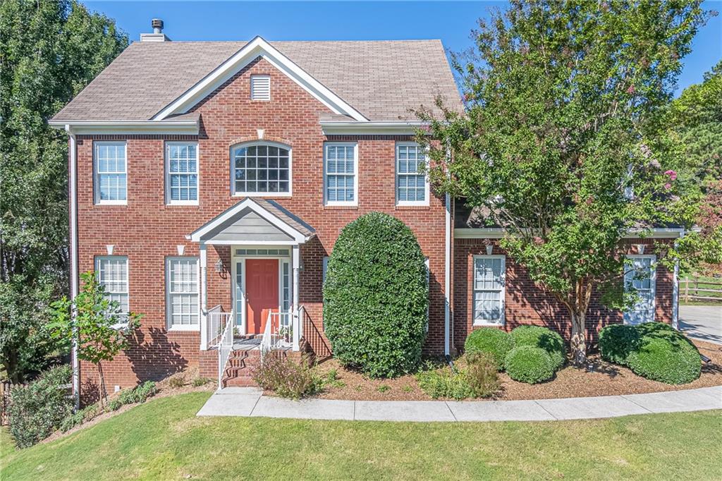 1030 Russell Point Suwanee, GA 30024 - Photo 1 of 1 a front view of a house with garden
