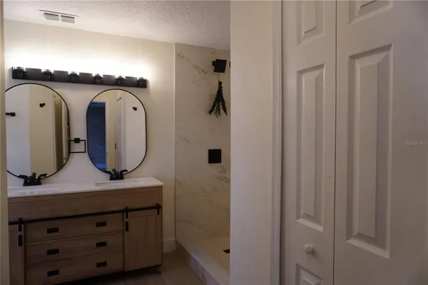 a bathroom with a granite countertop sink and a mirror