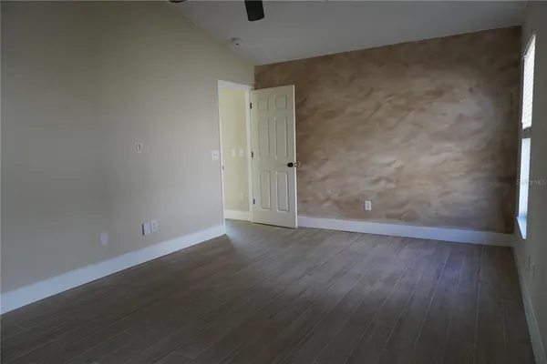 a view of an empty room with wooden floor