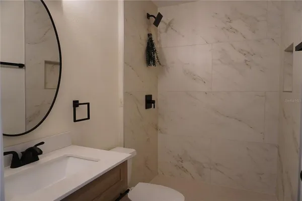 a bathroom with a sink a toilet and a mirror