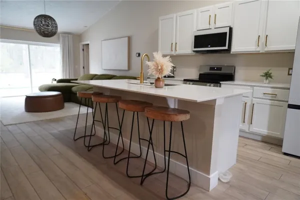 a kitchen with stainless steel appliances granite countertop a stove a sink a microwave and cabinets