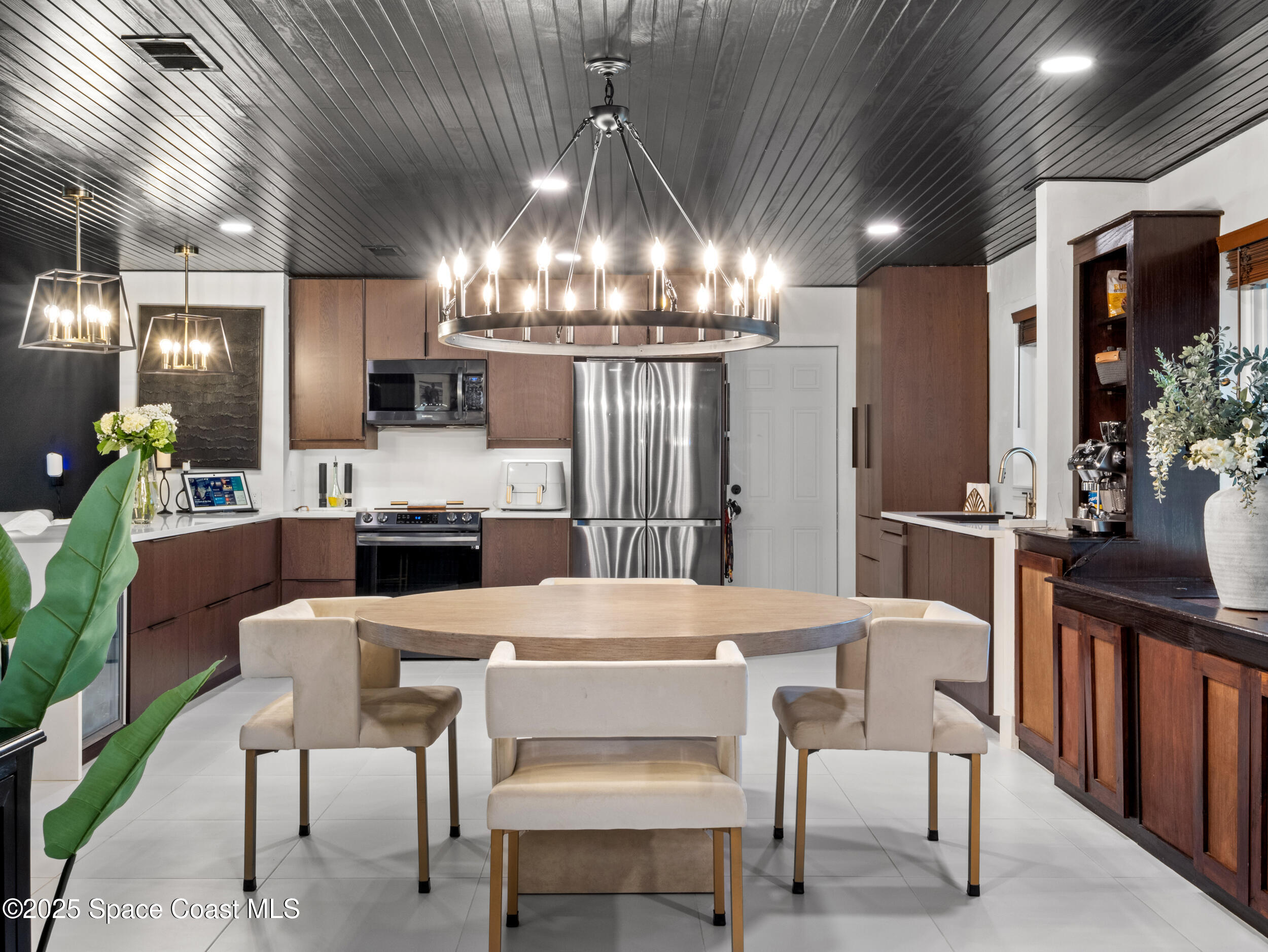 219 Sand Pine Road Indialantic, FL 32903 - Photo 11 of 38 a kitchen with a table chairs refrigerator and microwave