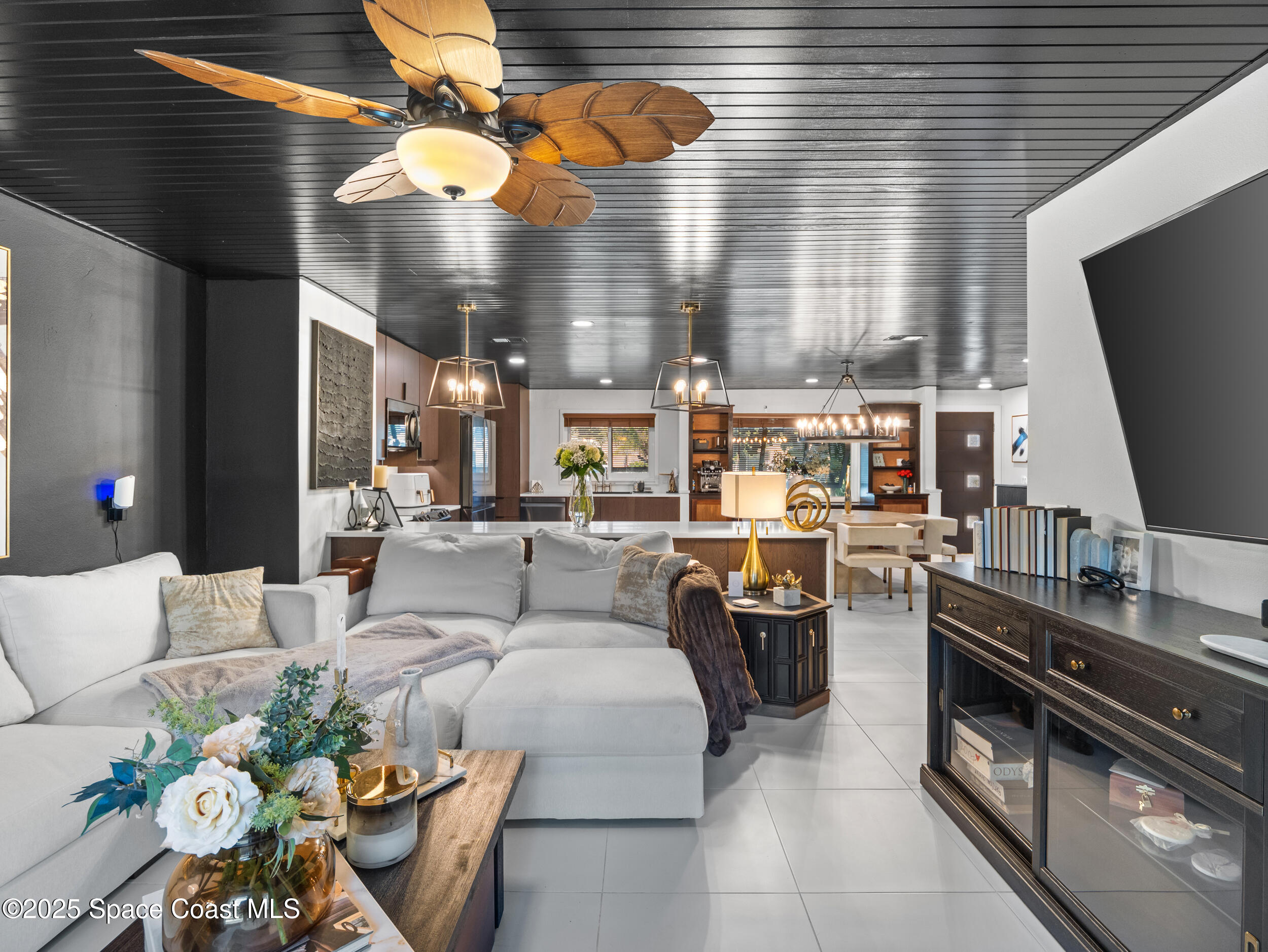 219 Sand Pine Road Indialantic, FL 32903 - Photo 13 of 38 a living room with furniture a flat screen tv and kitchen view