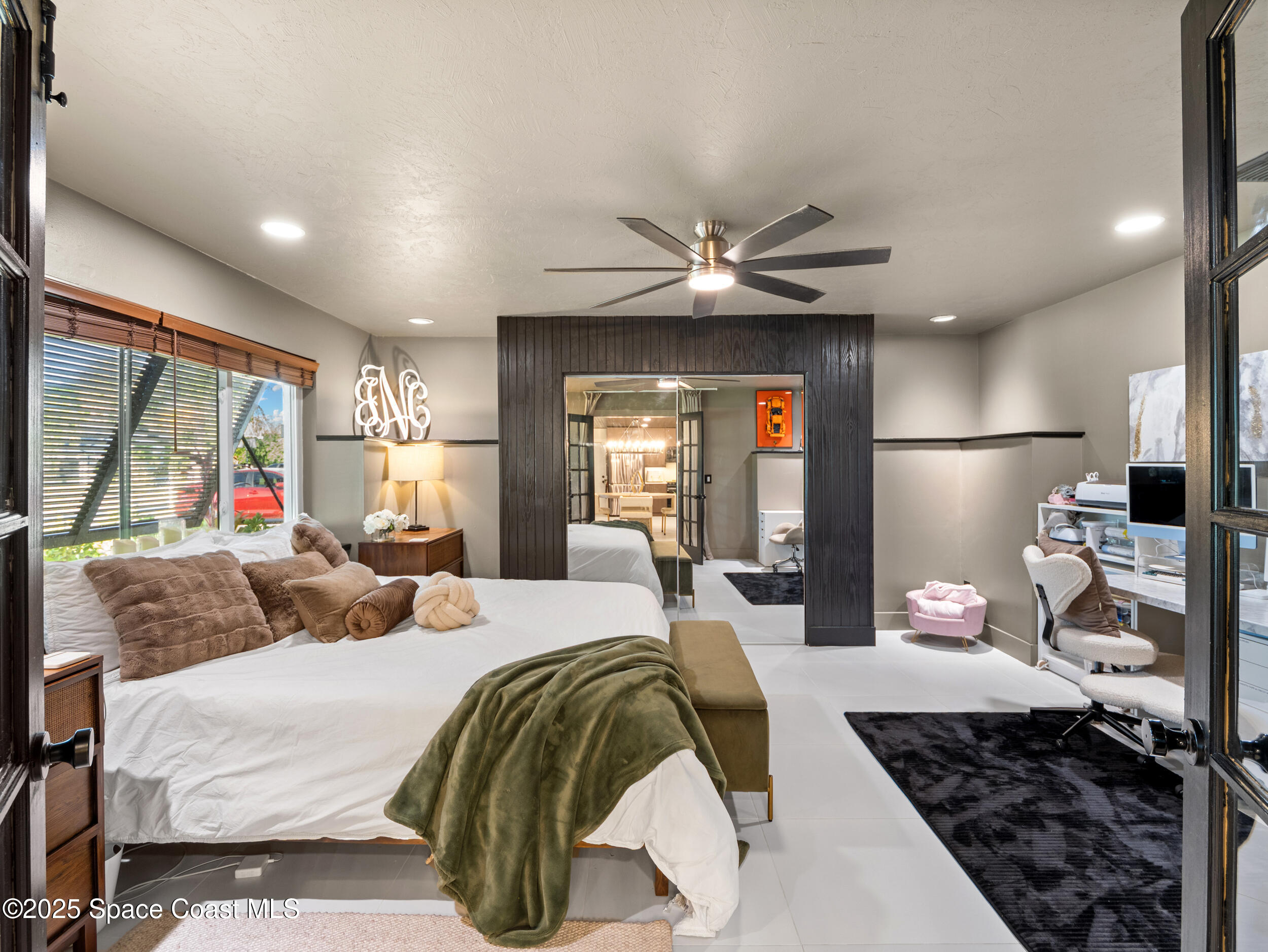 219 Sand Pine Road Indialantic, FL 32903 - Photo 19 of 38 a bedroom with a large bed and a chandelier