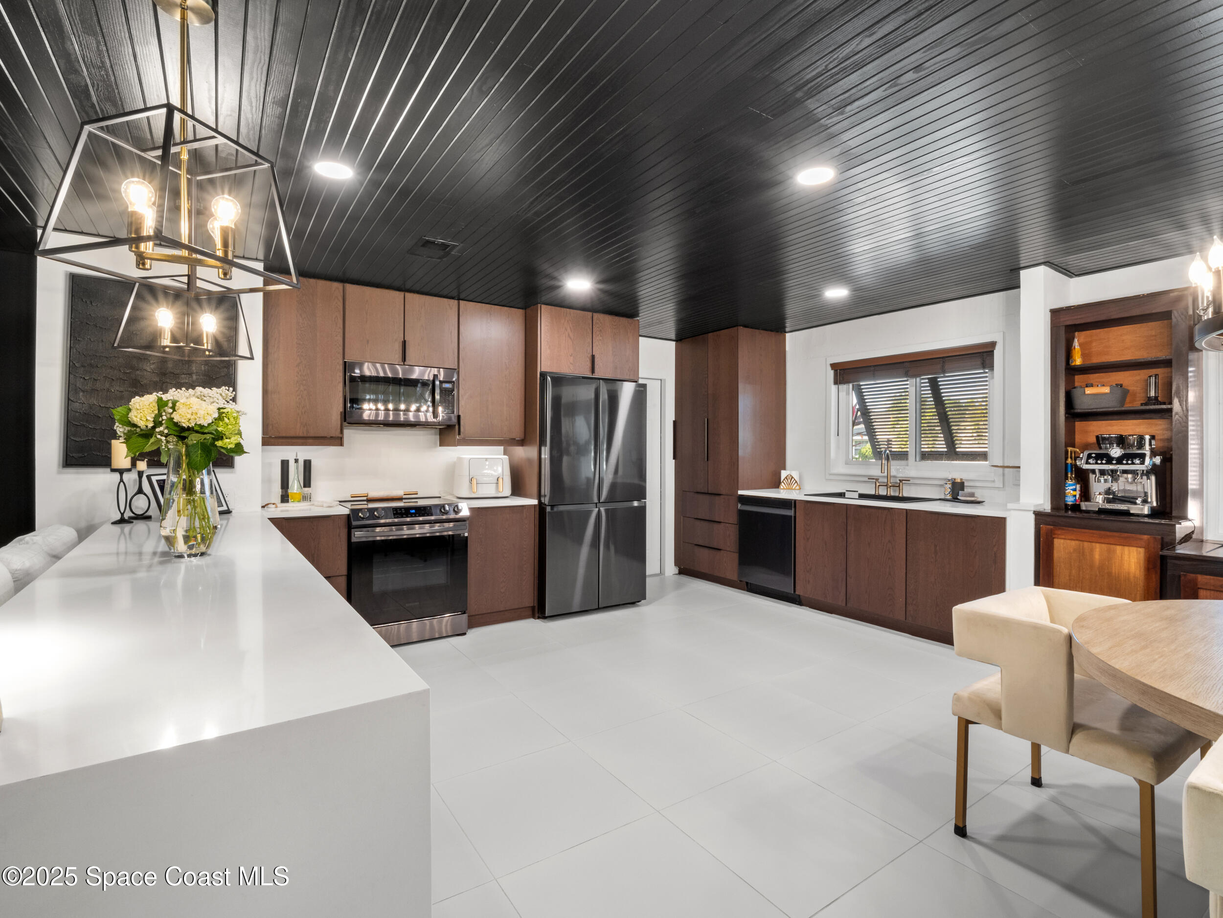 219 Sand Pine Road Indialantic, FL 32903 - Photo 2 of 38 a kitchen with stainless steel appliances a sink counter top space cabinets and a large window