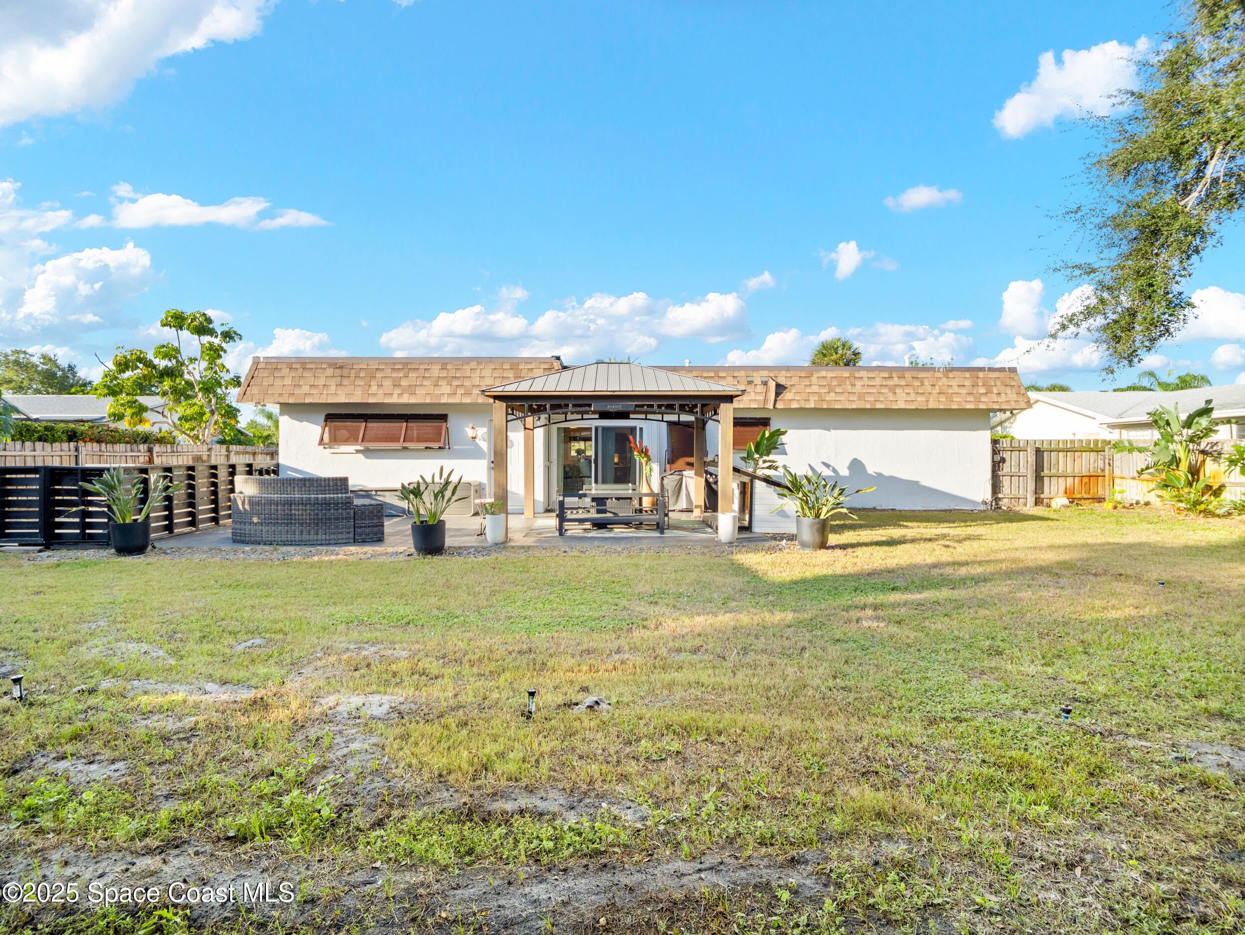 219 Sand Pine Road Indialantic, FL 32903 - Photo 26 of 38 a view of a house with backyard porch and furniture