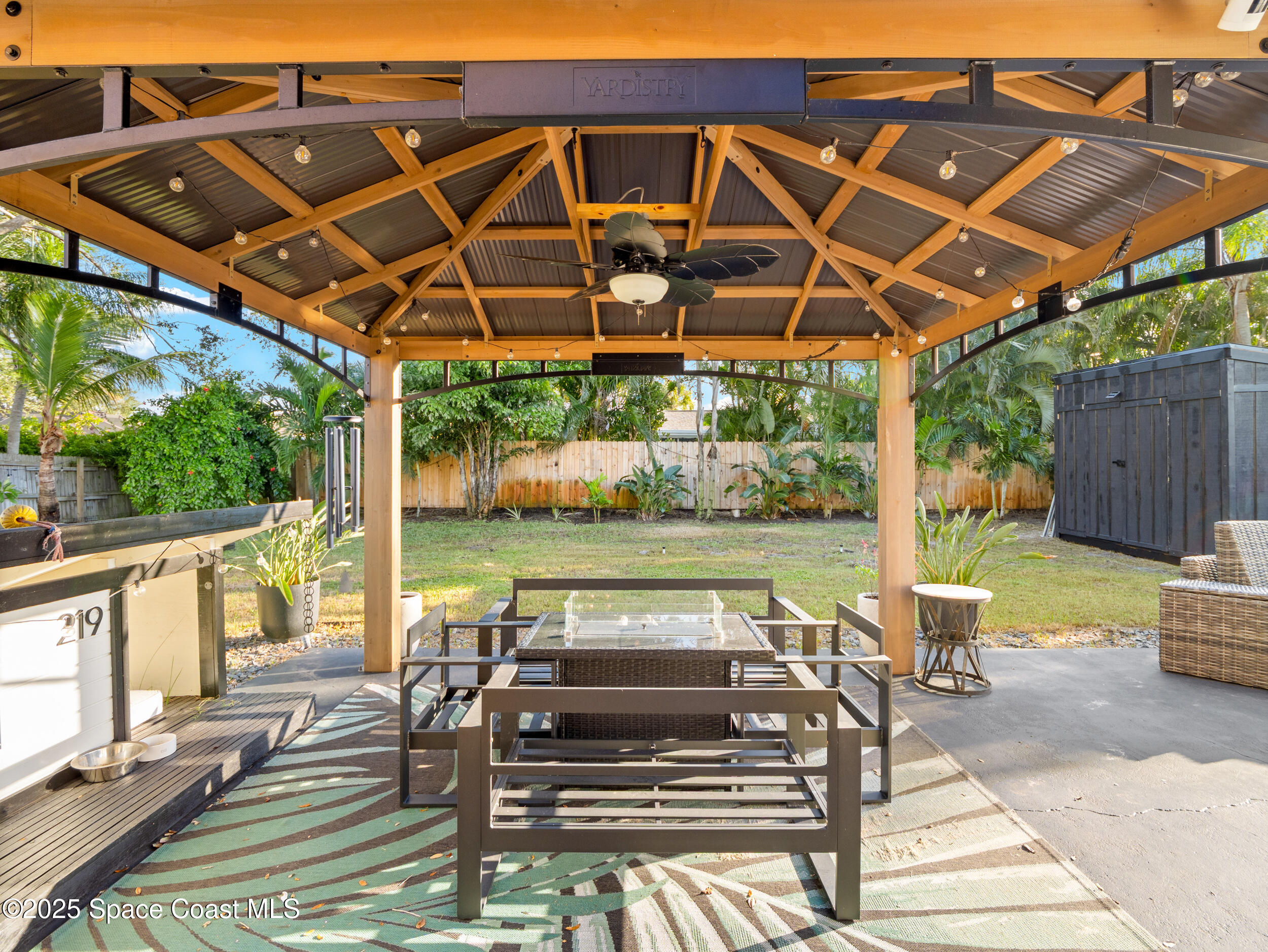 219 Sand Pine Road Indialantic, FL 32903 - Photo 28 of 38 a view of a patio with table and chairs under an umbrella