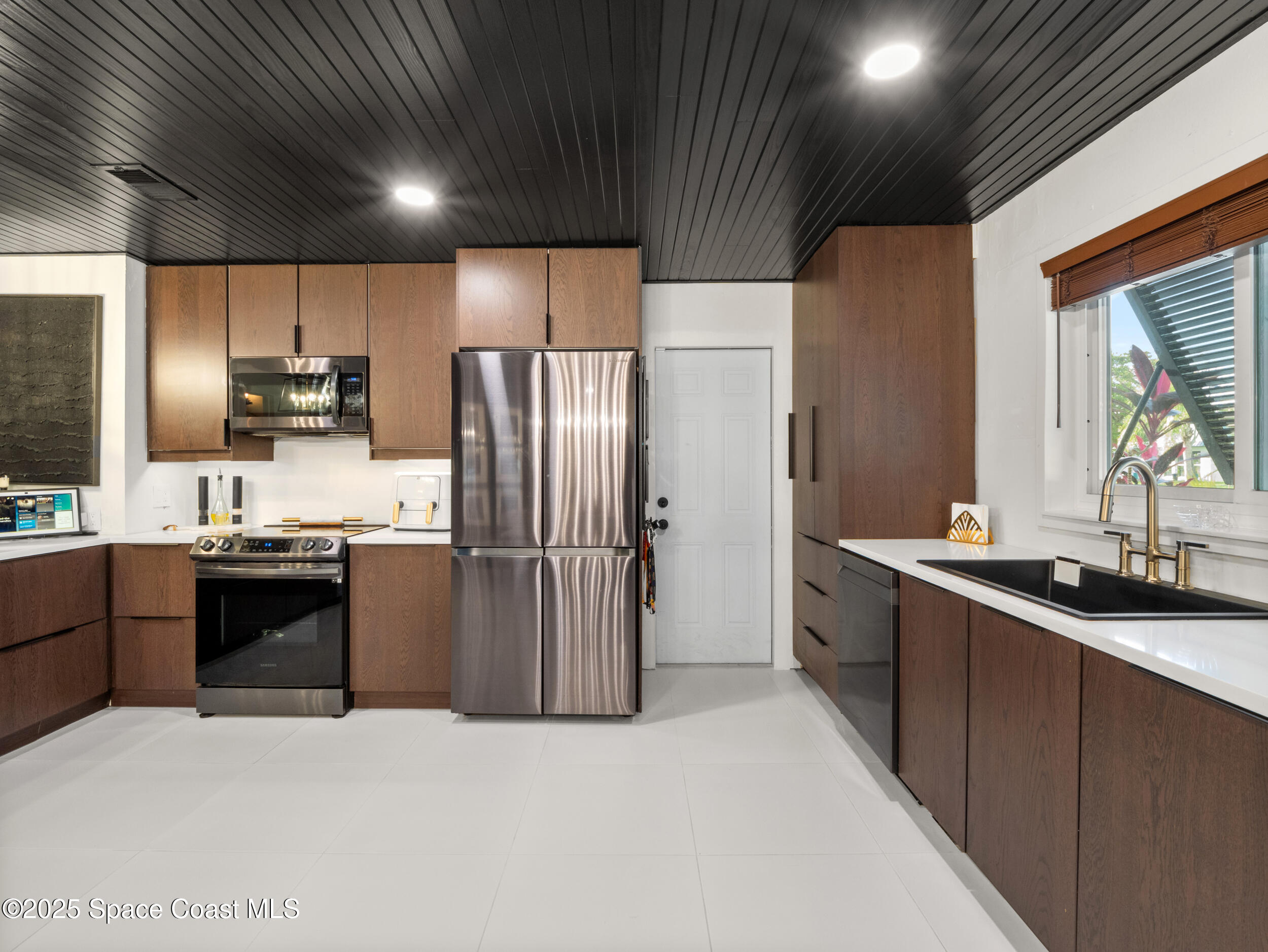 219 Sand Pine Road Indialantic, FL 32903 - Photo 7 of 38 a kitchen with stainless steel appliances granite countertop a refrigerator a sink a stove and a refrigerator