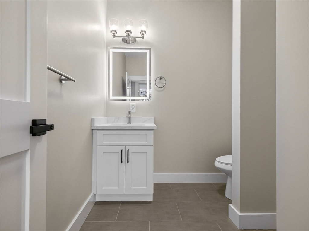60 Stanley Street, Unit 102 Boston, MA 02125 - Photo 13 of 15 a bathroom with a sink a toilet and a mirror