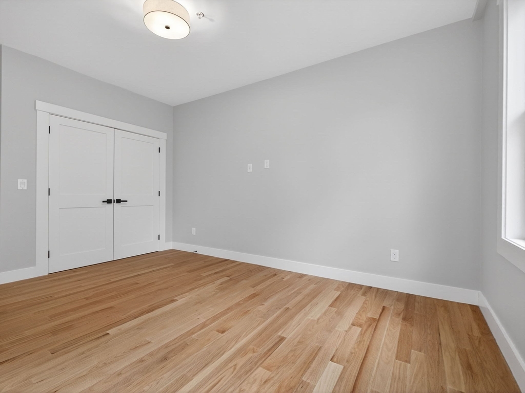 60 Stanley Street, Unit 102 Boston, MA 02125 - Photo 8 of 15 a view of an empty room with wooden floor