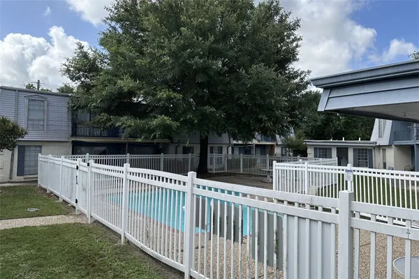 a white house that has tree in front of it