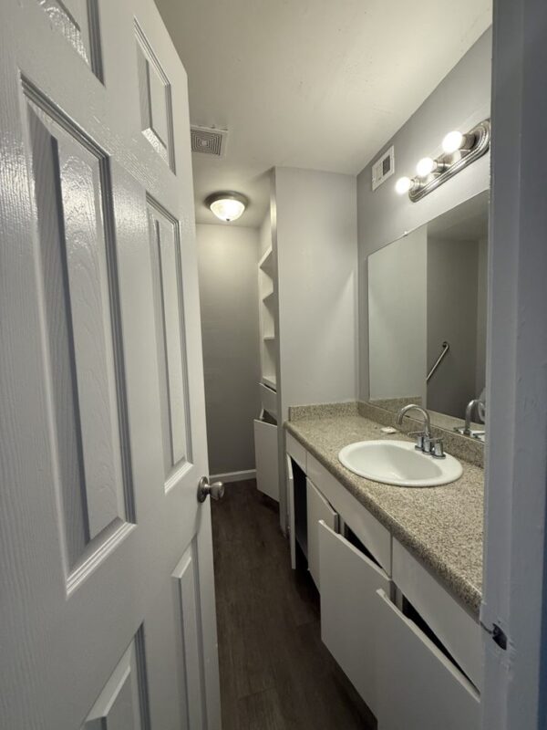 603 East 29th Street, Unit 4 Bryan, TX 77803 - Photo 5 of 6 a bathroom with a granite countertop sink a mirror and a shower