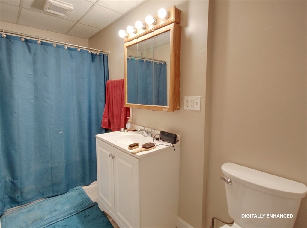 35 Windham Street Worcester, MA 01610 - Photo 21 of 39 a bathroom with a sink a toilet a mirror and shower curtain