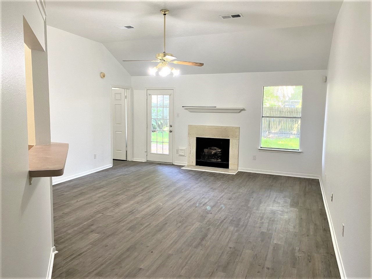 3011 Pheasant Run Humble, TX 77396 - Photo 4 of 17 an empty room with wooden floor fireplace and windows