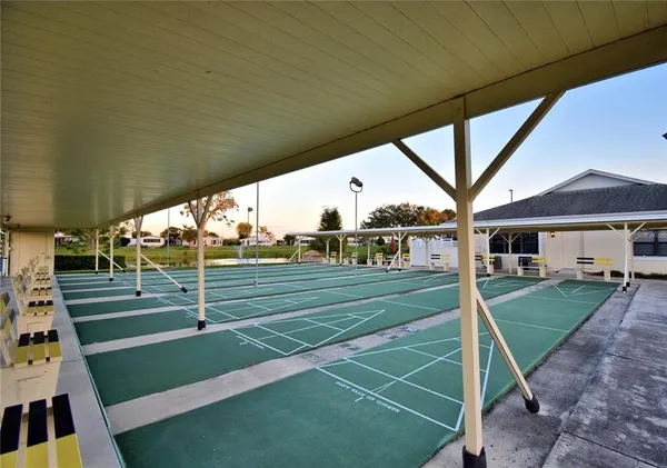 a view of a tennis ground with large trees