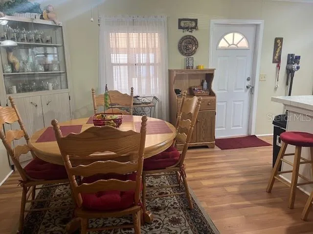 a living room with furniture a clock on wall and a window