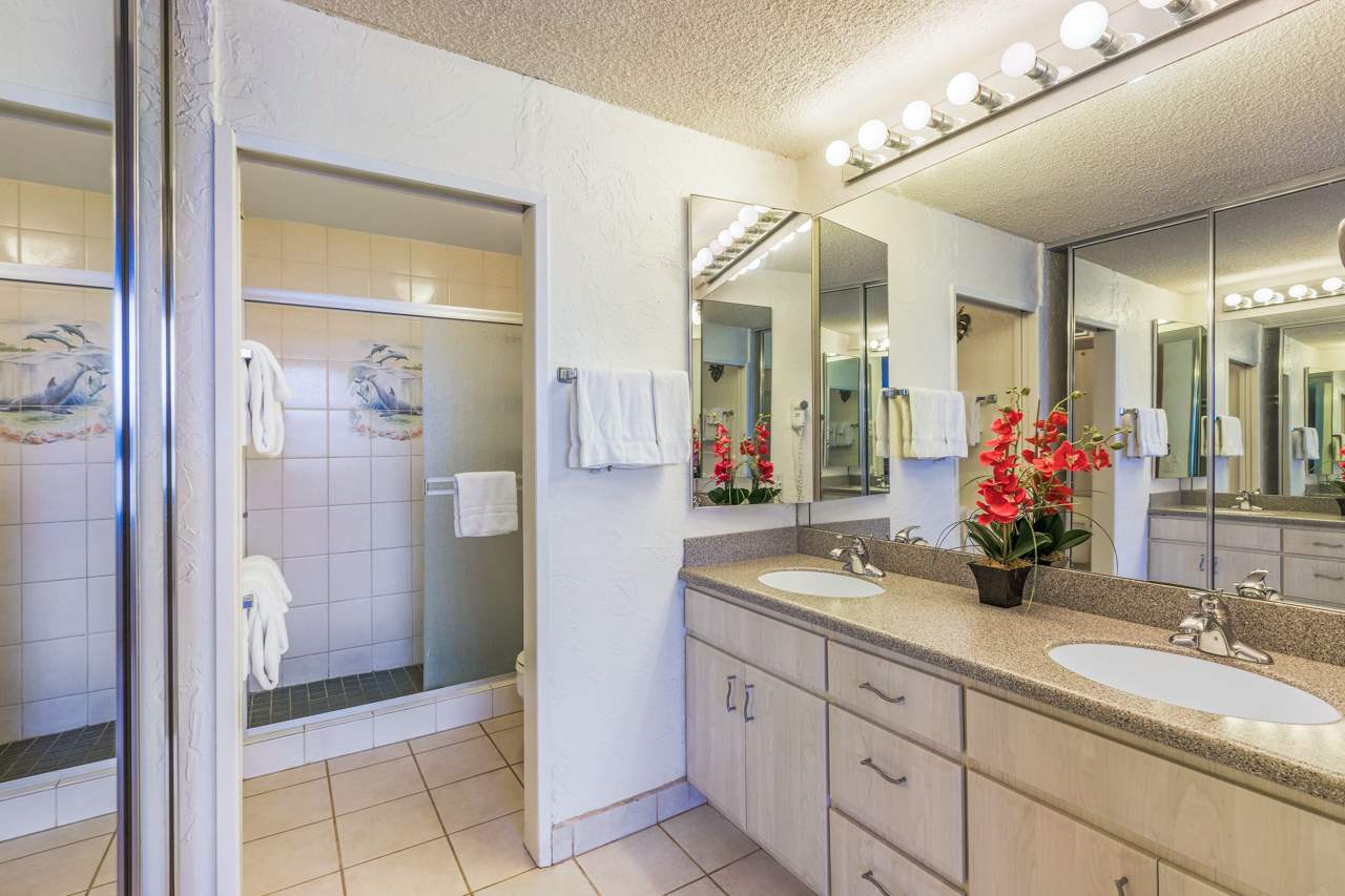 3543 Lower Honoapiilani Road, Unit F405 Lahaina, HI 96761 - Photo 13 of 30 a bathroom with a granite countertop sink a large mirror and a shower