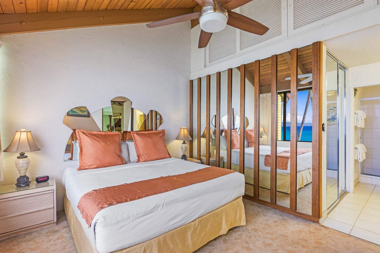 3543 Lower Honoapiilani Road, Unit F405 Lahaina, HI 96761 - Photo 14 of 30 a bedroom with a bed and a chandelier