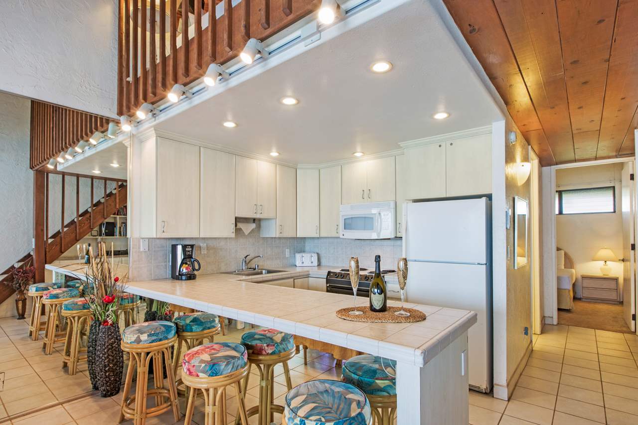 3543 Lower Honoapiilani Road, Unit F405 Lahaina, HI 96761 - Photo 23 of 30 a kitchen with stainless steel appliances granite countertop a refrigerator a stove and a sink