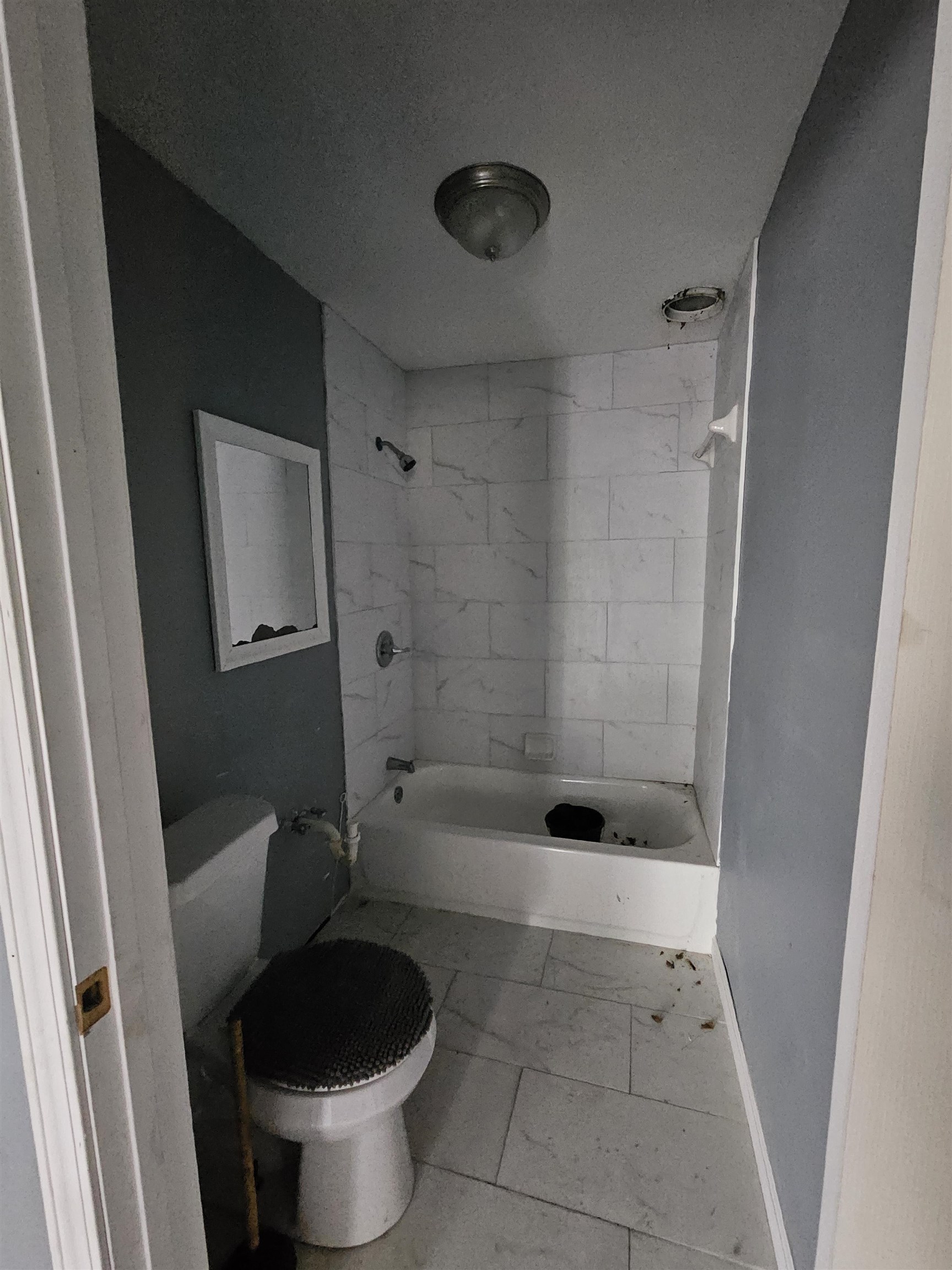 2059 Swift Street Memphis, TN 38109 - Photo 8 of 12 Bathroom featuring white subway tile shower surround, a white bathtub, and a white toilet
