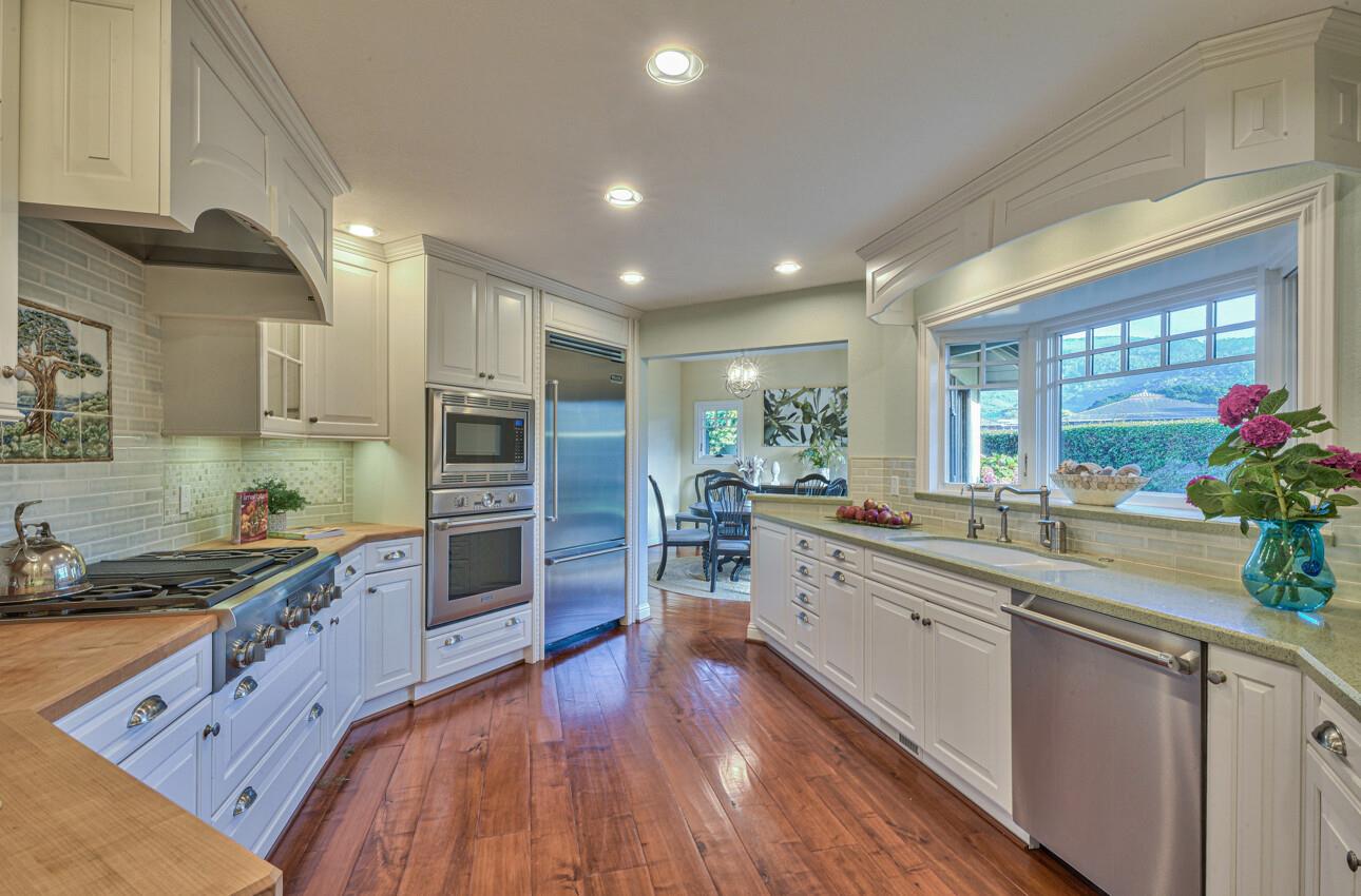 8022 River Place Carmel, CA 93923 - Photo 21 of 39 a large kitchen with stainless steel appliances granite countertop a lot of counter space and wooden floors