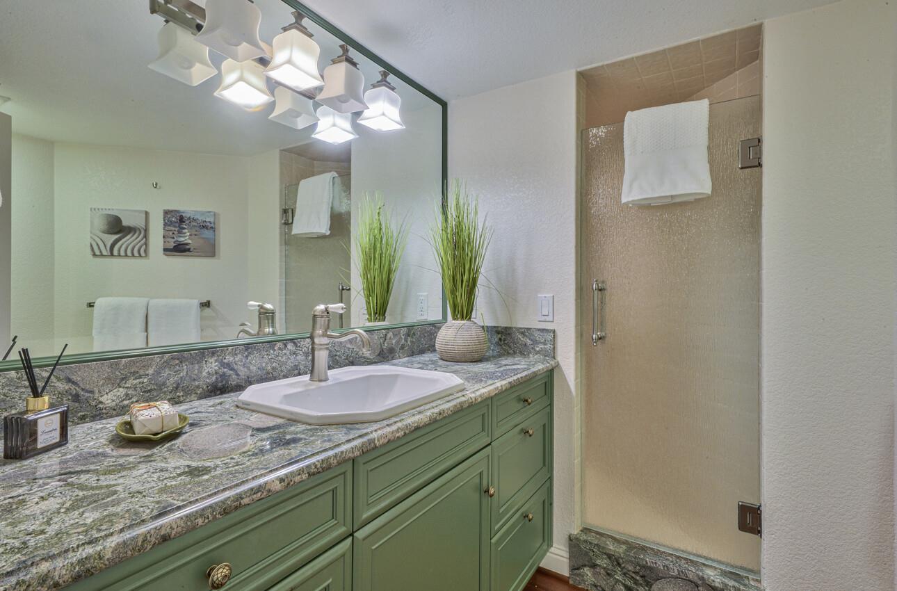 8022 River Place Carmel, CA 93923 - Photo 22 of 39 a bathroom with a granite countertop sink and a mirror