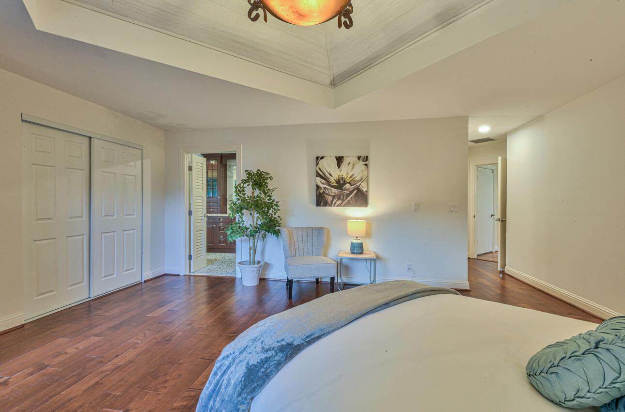 8022 River Place Carmel, CA 93923 - Photo 25 of 39 a bedroom with a bed and wooden floor