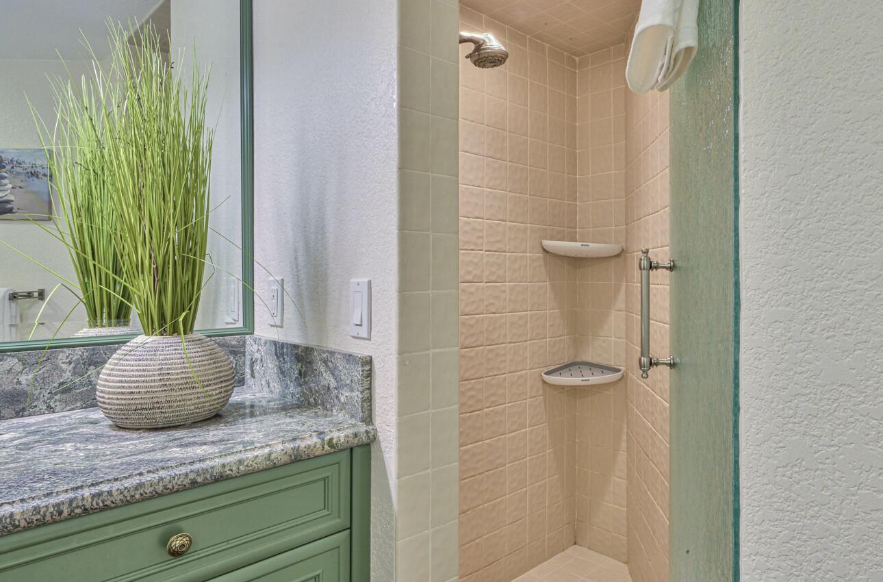 8022 River Place Carmel, CA 93923 - Photo 33 of 39 a bathroom with a granite countertop sink a mirror and shower