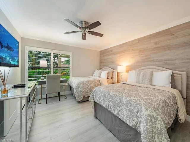 a bedroom with two beds and large window