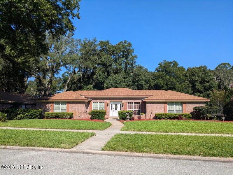 4442 River Trail Road Jacksonville, FL 32277 - Photo 14 of 38 a front view of a house with a yard table and chairs