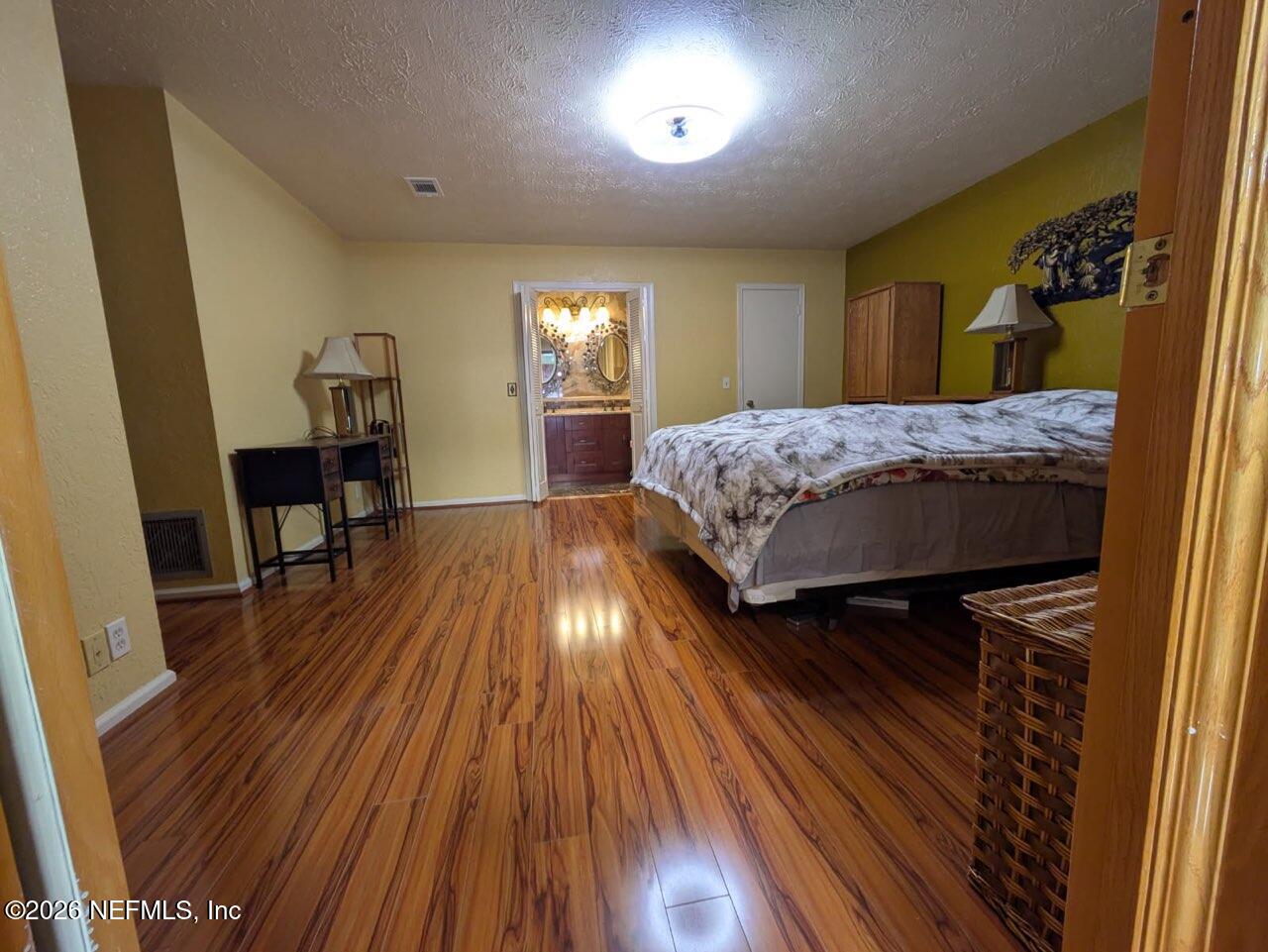 4442 River Trail Road Jacksonville, FL 32277 - Photo 37 of 38 a bedroom with a bed and wooden floor