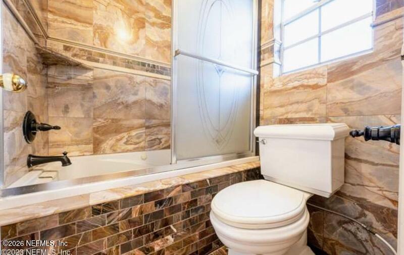 4442 River Trail Road Jacksonville, FL 32277 - Photo 6 of 38 a white toilet sitting next to a bathroom sink and tub