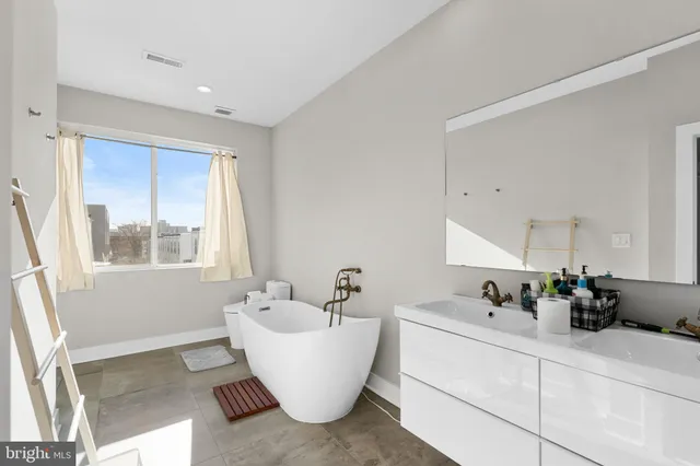 a bathroom with a bathtub sink and mirror