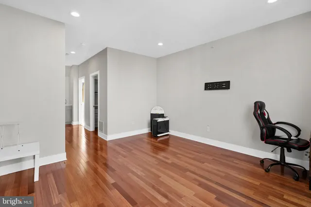 a view of a livingroom with wooden floor and a workspace
