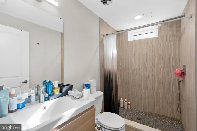 a bathroom with a sink a toilet and shower