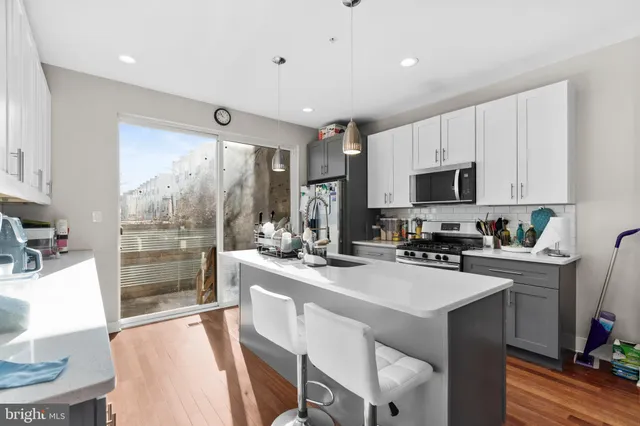 a kitchen with a sink a counter top space appliances and cabinets
