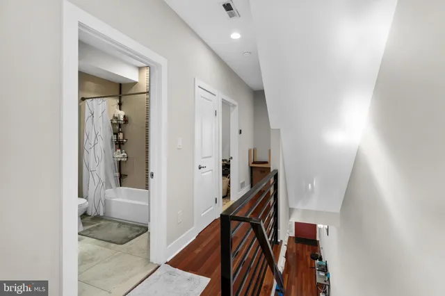 a view of a hallway with a livingroom and a bathroom