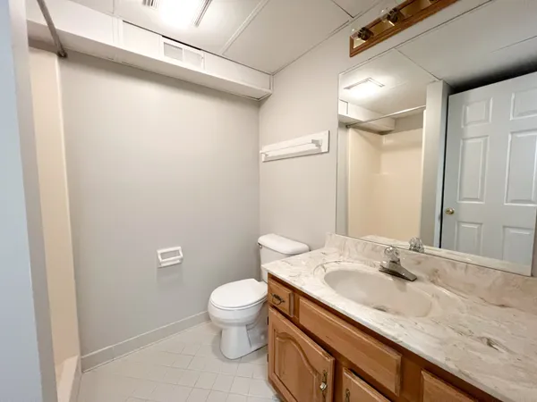 a bathroom with a granite countertop sink a toilet and a mirror