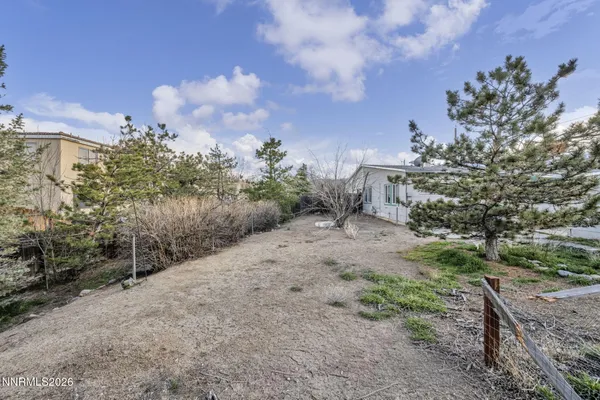 a view of a yard with wooden fence
