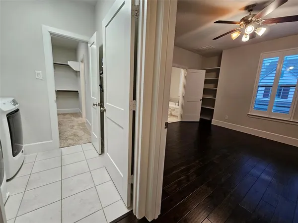 an empty room with wooden floor cabinet and windows
