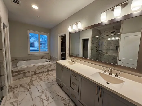a bathroom with a bathtub shower sink and mirror