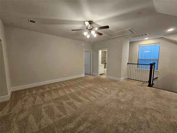 a view of an empty room and chandelier fan
