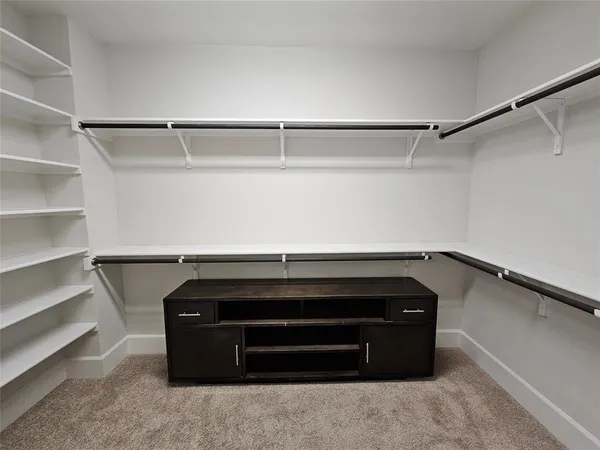 a large white kitchen with kitchen island a island wooden floor and stainless steel appliances