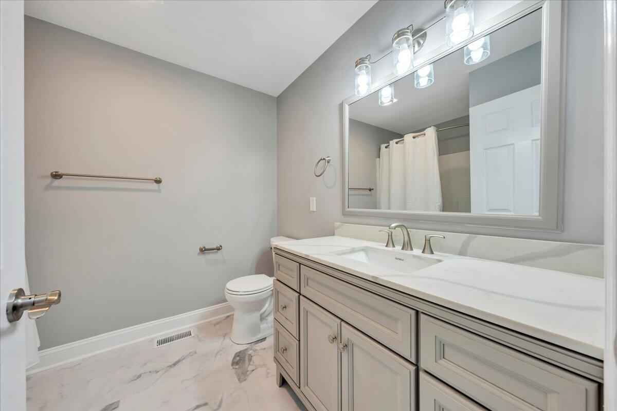 1510 Navigation Point Goodview, VA 24095 - Photo 19 of 48 a bathroom with a granite countertop sink a toilet and a mirror