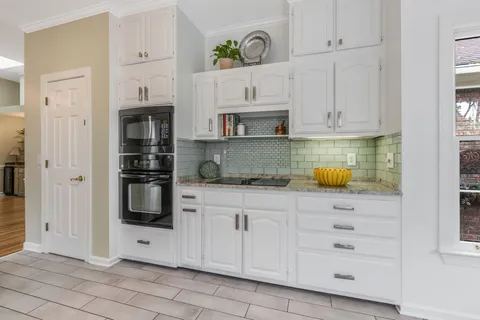a kitchen with white cabinets and appliances