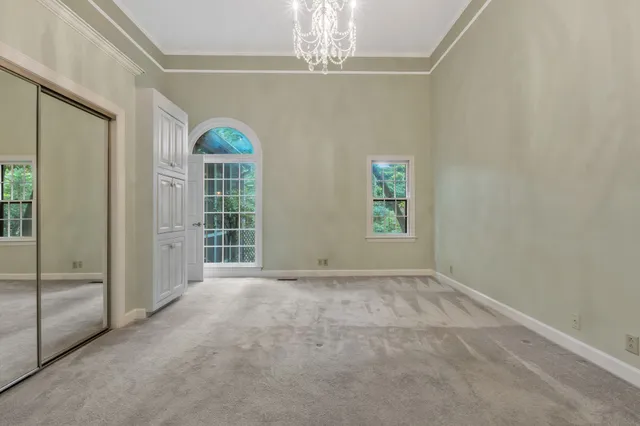 an empty room with chandelier and glass door